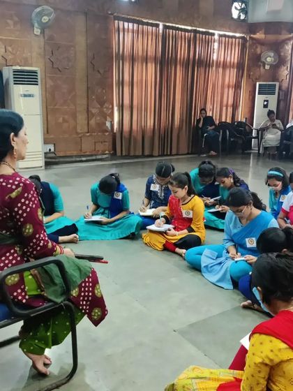 A moment of quiet focus during a workshop in Guwahati, where students take notes on dance theory. Understanding the 'why' behind the movement is as important as the physical practice itself.