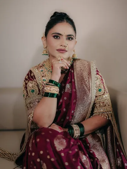 A powerful portrait of our Maharashtrian bride. The makeup features strong, defined eyes and a matte mauve lip, creating a look that is both modern and deeply traditional.