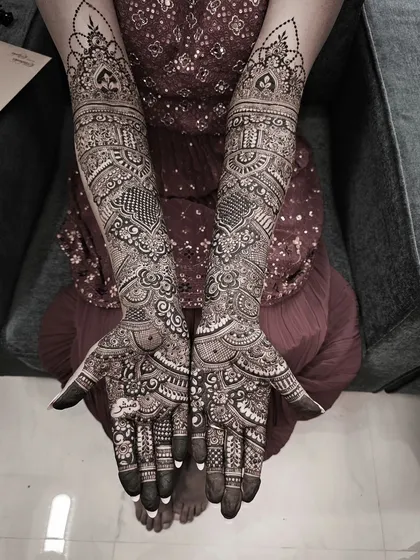 This black and white shot emphasizes the texture and complexity of a full bridal design, showing the depth and layers of the henna pattern.