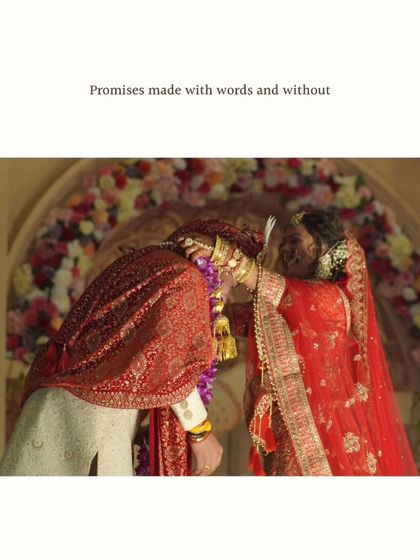 The Varmala or Jaimala exchange is a beautiful and significant ritual. This shot captures the moment of the promise, framed by a stunning floral arch, symbolizing the start of a new journey together.