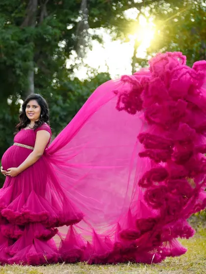 A breathtaking outdoor shot with a magenta gown's train flying in the wind. The golden hour light and the dynamic pose create a powerful and magical portrait.
