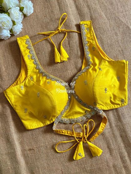 A bright yellow blouse with a modern wrap-around tie detail. The subtle embroidery adds a touch of festive charm.