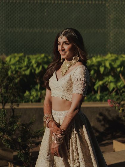 Sheena’s golden hour bridal look was all about understated luxury. We used a lightweight, luminous base and a soft nude lip to complement her stunning ivory lehenga, creating a perfect blend of tradition and modern elegance.