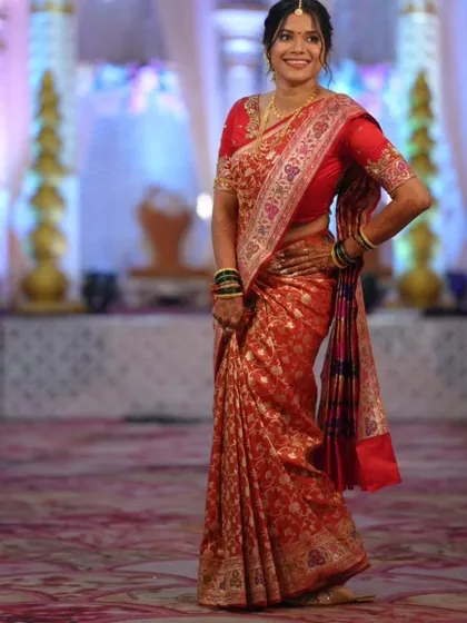 A full-length shot showing the beautiful drape of the red Paithani-style saree, perfect for making a grand entrance.