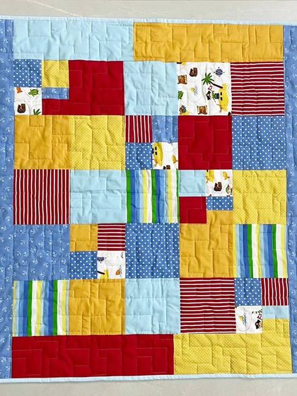 A top-down view of the primary-colored baby quilt, an excellent example of a simple yet impactful design for beginners.