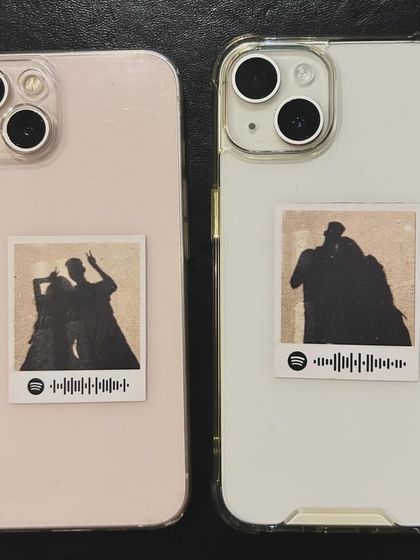 A direct, top-down view of the custom phone case stickers with silhouette illustrations and Spotify codes.