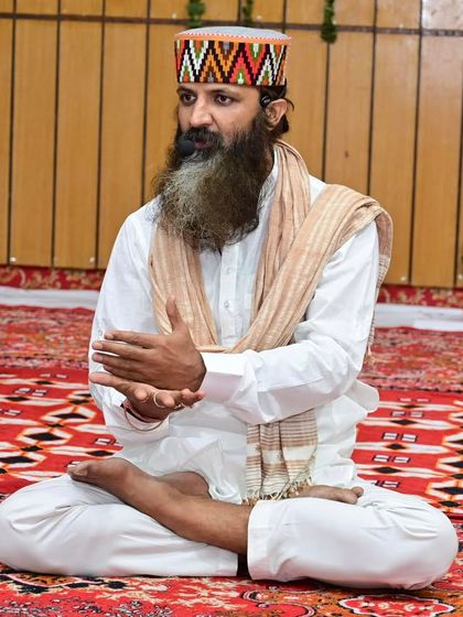 Seated in Padmasana, I am explaining a concept during a teaching session. My hands are in Jnana Mudra, a gesture that symbolizes wisdom and the connection between the individual and the universal consciousness.