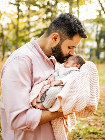 A father's gentle kiss for his newborn son during the magical golden hour. These are the fleeting, tender moments I live to capture, telling the story of your family's love.