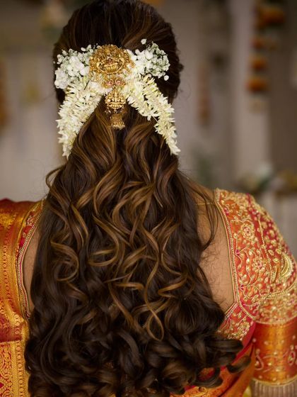 A back view of the half updo, showing the beautiful arrangement of the gajra and the gold hair accessory.