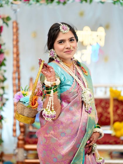 Ready for her baby shower ceremony. The complete look, with the traditional saree, floral accessories, and radiant makeup, comes together to create a picture of pure grace and joy.
