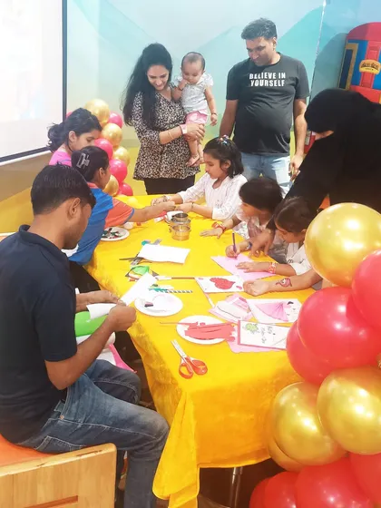 Families gather around a table for a group crafting session during our Mother's Day event.