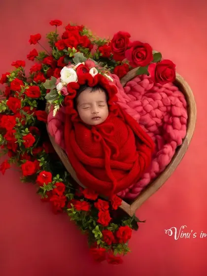 Color can add so much emotion to a portrait. This vibrant, all-red theme uses a heart-shaped prop and rich floral arrangements to create a powerful and passionate statement of love for this beautiful baby girl.