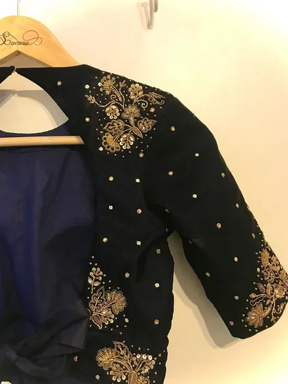 A full view of the sleeve and shoulder embroidery on a custom black velvet blouse, designed to complement a variety of sarees.