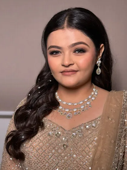 For her engagement, we went with a glitzy yet sophisticated look. The makeup features a classic brown smokey eye, while the hair is styled in soft waves with delicate pearl accessories for a touch of sparkle.