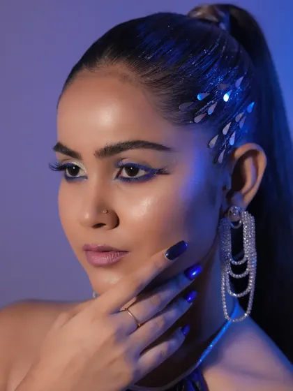 This angle highlights the shimmering details in the hair and the glossy, reflective skin finish, techniques often used in editorial photoshoots.