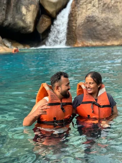 A couple enjoying the refreshing waters of Blue Lagoon Falls. It's a perfect spot for both adventure and creating romantic memories.