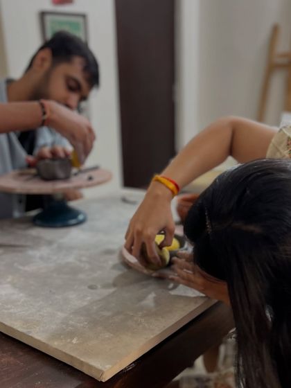 Working side-by-side, this couple adds details to their individual pieces during their anniversary celebration. It's a lovely balance of individual creativity and shared experience.