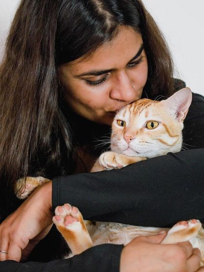 A tender moment between Akanksha and her cat, Jerry. The gentle kiss on the head speaks volumes about their loving relationship.