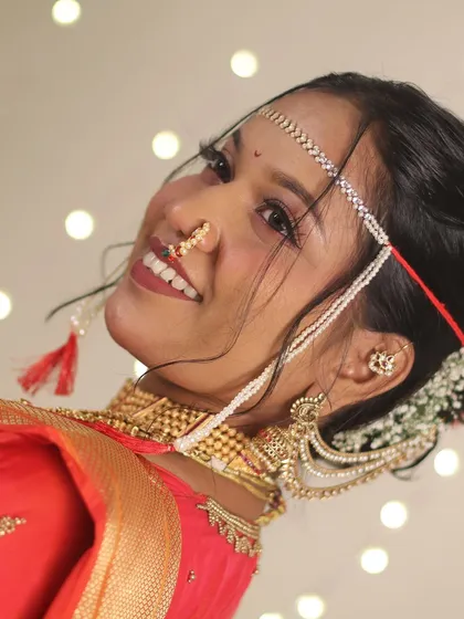 A bright, angled smile from the bride. This shot shows off her traditional nath and the beautiful bokeh background.
