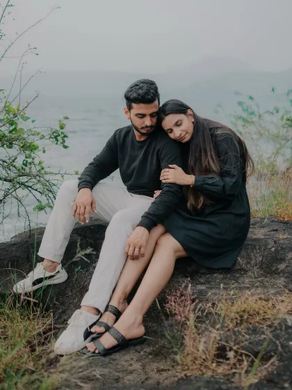 A quiet, tender moment by the lakeside. The moody lighting and natural setting create a serene and intimate atmosphere, perfect for capturing the couple's deep connection.