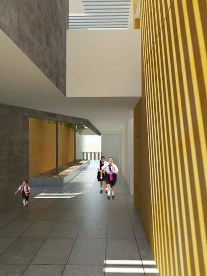 A hallway in the proposed school, illustrating the material palette of exposed concrete and vertically slatted yellow walls. This combination adds texture and warmth to the interior spaces while maintaining a modern, minimalist aesthetic.