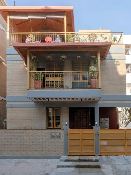 The front facade of Audumbara, showcasing the use of CSEB and the prominent balconies that define its character.
