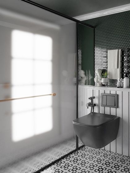 The shower and WC area of the retro bathroom, with a frosted glass partition and classic black-and-white patterned floor tiles.