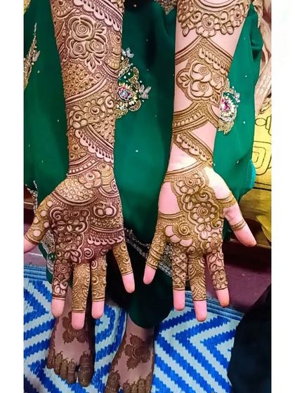 A beautiful bridal design with a focus on rose motifs and delicate leaf patterns, shown on the palms.