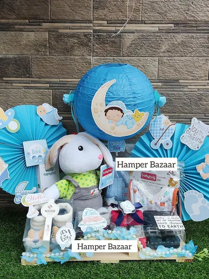 A large, elaborate baby boy hamper featuring a soft toy, baby essentials, and a decorative paper lantern.