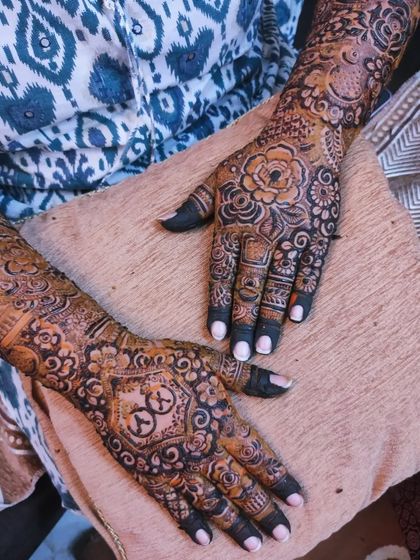 The beautiful and intricate mehndi for bride Kulsum, featuring her groom's name 'Irfan' on her palm.
