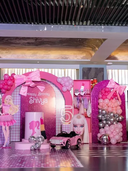 Welcome to the Barbie Dream House. This elaborate setup features a life-sized Barbie box for photos, a pink convertible, and a runway, all designed to make the birthday girl feel like a star. I love bringing popular themes to life with glamorous, detailed decor.