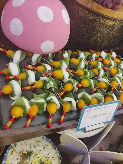 A close-up of the Caprese skewers on a boat-shaped platter, part of a larger grazing table. I love using creative plating to make even simple dishes look special and inviting.