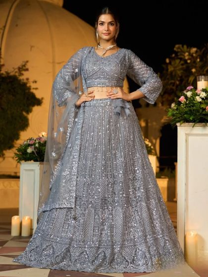 A powerful pose that showcases the full, voluminous skirt of the grey lehenga and its dazzling embellishments.