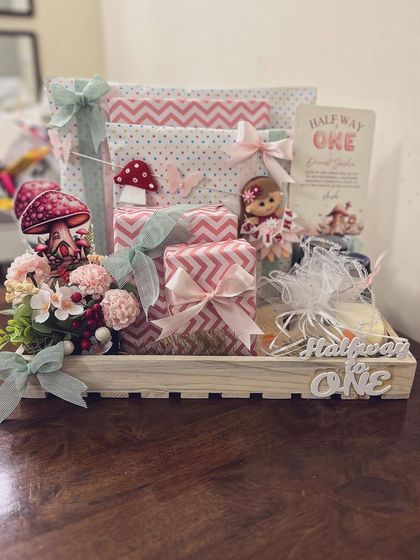 The full "Halfway to One" hamper, beautifully arranged in a rustic wooden tray with themed decorations and carefully wrapped gifts.