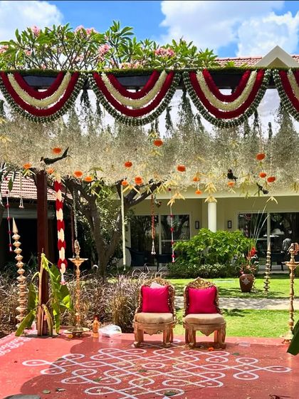 A closer look at a traditional South Indian mandap design. The stage floor features a hand-painted kolam design, and the canopy is decorated with tuberose and marigold garlands, reflecting authentic wedding traditions.