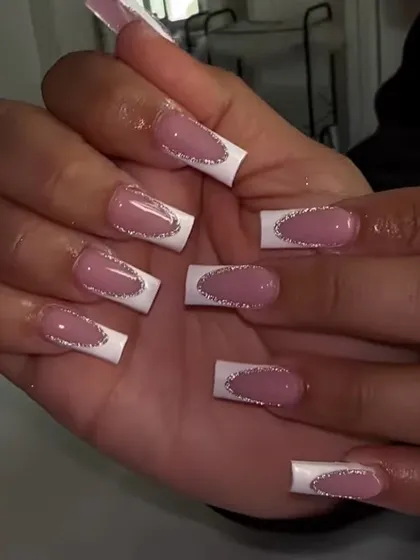 A detailed view of the glitter-lined French manicure, showing how the silver sparkle defines the shape of the white tips.