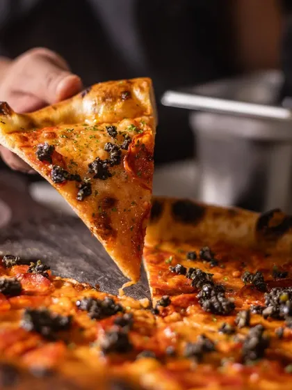 Grabbing the first slice of a Pepperoni and Truffle pizza. It's a moment of pure anticipation and joy.