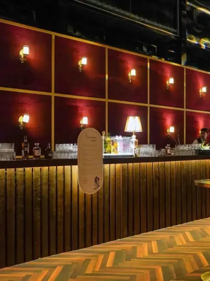 A custom-built bar is a key feature of our themed events. This one featured a fluted wood base, a rich velvet back panel with brass accents, and warm sconce lighting to create an inviting, high-end lounge feel.