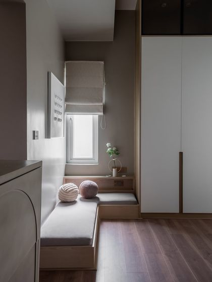 A closer look at the master bedroom from our "Design That Breathes" project. The space features a textured stone accent wall, a warm earthy palette, and a cozy reading nook that doubles as a calm retreat.