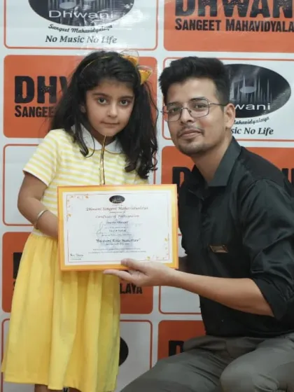 A teacher presents an award to a young student.