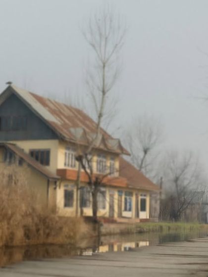A couple walks past a traditional house in a Kashmiri village, blending their story with the local scenery. This style of environmental portraiture adds a rich narrative layer to your pre-wedding photos.