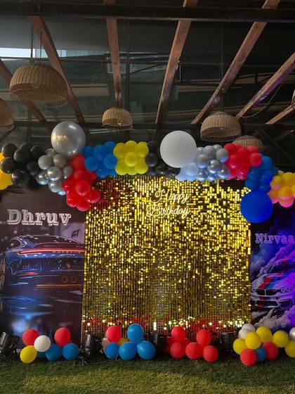 Another view of the car-themed joint birthday party, showing the vibrant balloon colors and the impressive scale of the outdoor setup.