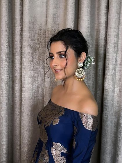 A side view of the soft and minimal look, showcasing the elegant updo with a fresh flower. This is perfect for someone who wants to look classy and understated.