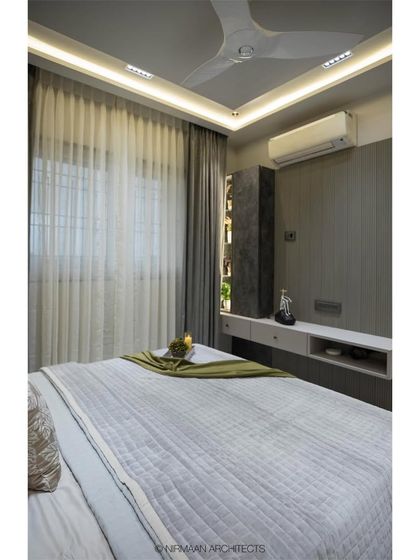 A view of the master bedroom in the Duplex Project, showing the clean lines and sophisticated grey palette. The design focuses on creating a tranquil and uncluttered space.