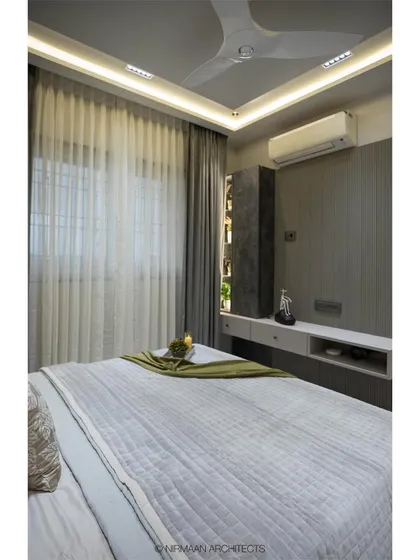 A view of the master bedroom in the Duplex Project, showing the clean lines and sophisticated grey palette. The design focuses on creating a tranquil and uncluttered space.