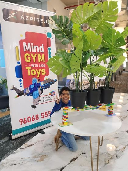 Success! A young engineer tests the strength of a bridge he constructed entirely from LEGO bricks, proving that play can teach real-world physics and engineering principles.