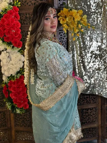 A full view of the Haldi bride's look, showing her beautiful pastel green outfit and the long, flowing hairstyle with a floral braid.