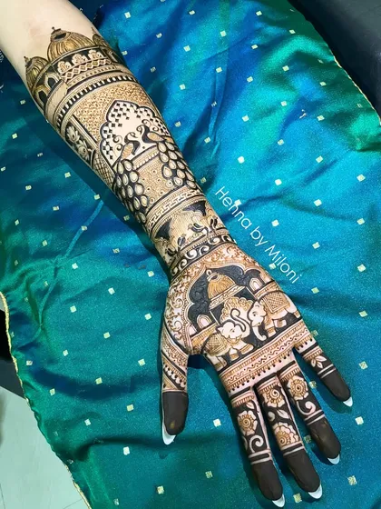 A stunning bridal mehendi with elephants, peacocks, and architectural details. The dark, bold application ensures a beautiful, long-lasting stain.
