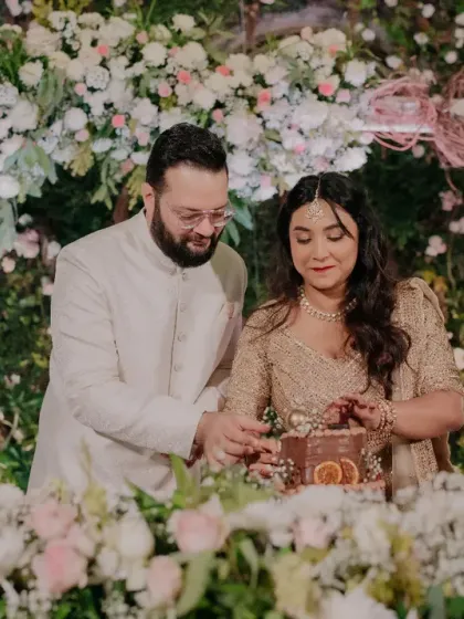 A post-wedding reception should feel like a warm hug, and that’s exactly what we created for this lovely couple. Surrounded by a wall of pastel florals and soft greenery, their cake-cutting moment was both sophisticated and deeply personal.