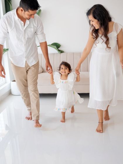 A family walking together, full of movement and happiness. The little girl's smile is infectious.